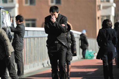 12月1日,北风呼啸,一名男子走在街头,刺骨的寒风让他赶忙裹紧外衣。图/东方IC